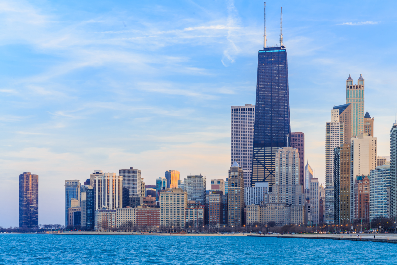 Chicago skyline along Lake Michigan at dusk with the John Hancock Center and waterfront high-rises