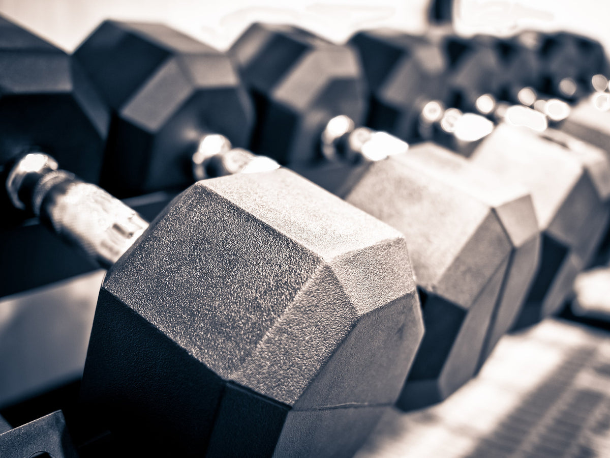 Close-up of hex dumbbells on a gym rack with shallow depth of field